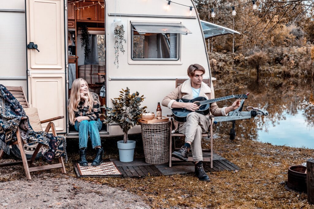 couple in love together having fun, young man and woman newlyweds spending time together near traile
