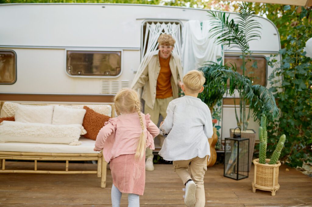 Father and children play at the trailer, camping