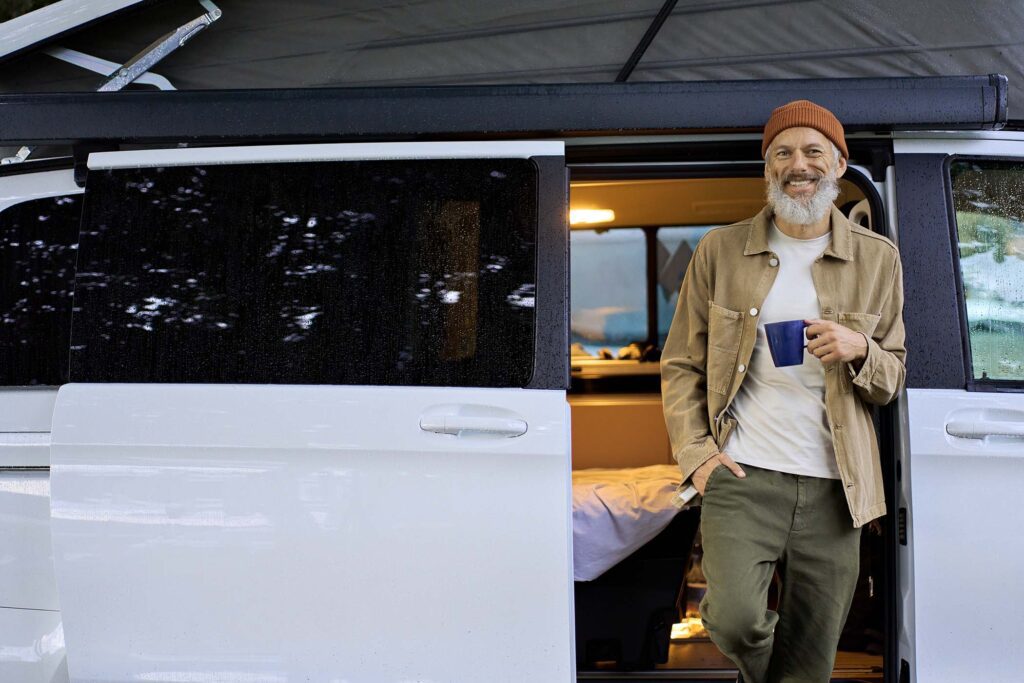 happy-old-man-traveler-standing-near-camper-van-dr-8ZJVU7P.jpg