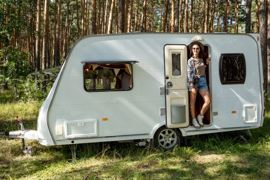 Happy young woman enjoying sunny day in travel house