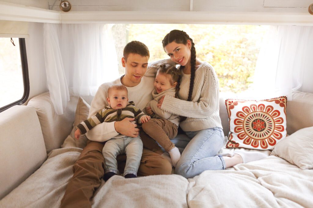 Portrait of the smiling happy family with kids in the house on wheels