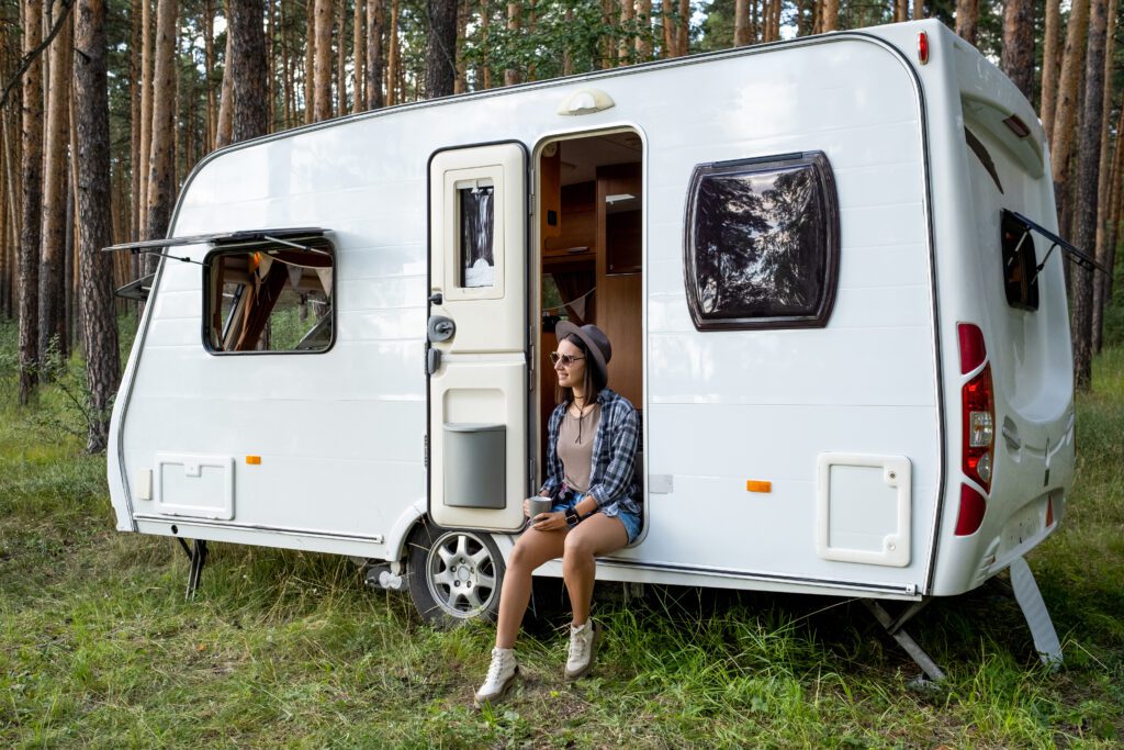 Young female hiker with cup of tea enjoying summer day